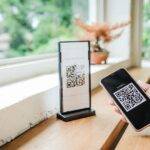 A woman is using her phone to scan a QR code using a reputation management tool.
